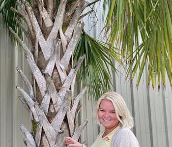 Blonde female smiling under palm tree